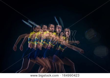 Portrait of beautiful girl tennis player with a racket on dark studio background. Stroboscope shooting technique