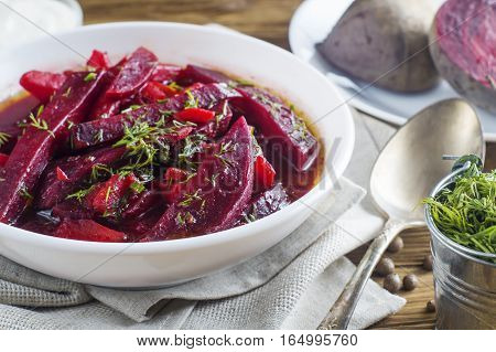 Vegetable soup - red borsch in a white bowl on a rustic wooden background clouse up. Healthy beetroot soup vegetarian food. Delicious beet soup with dill.