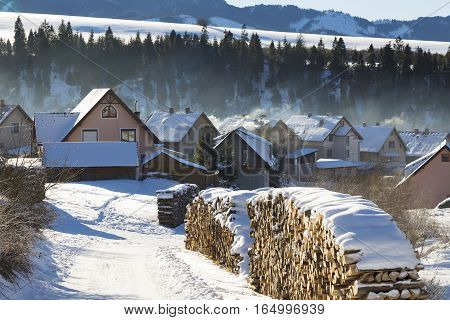 Winter rural landscape - mountain village covered with snow misty morning. Western Tatras. Slovakia. Orava region. Travel destination for winter vacations and skiing.