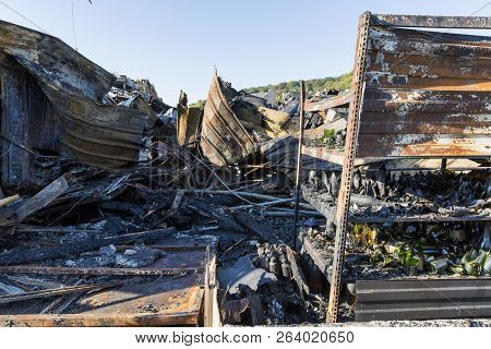 Damaged Industry Supermarket After Arson Fire With Burn Debris Of Twisted Metal Wood Structure After
