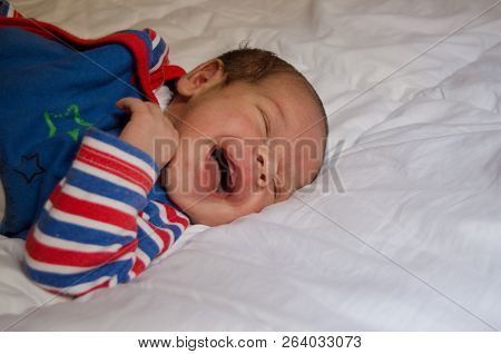 Two Weeks Old Newborn Baby Boy Smilin While Sleeping On White Quilt