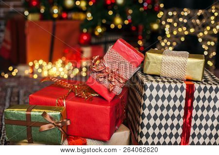Close Up Christmas Gift Box. Christmas Presents In Red And Brown Boxes On Christmas Tree Background 