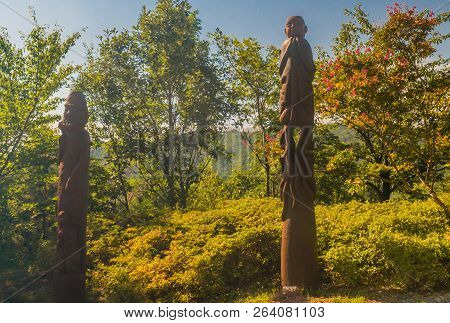 Samcheok, South Korea; September 25, 2018: Two Phallic Shaped Wooden Statues Standing In Front Of Gr