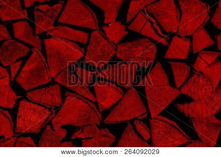 Red Firewood Background Stacked In A Woodpile