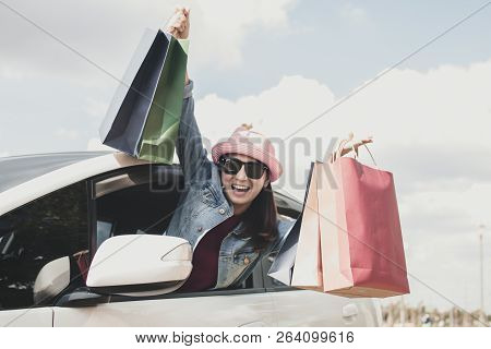 Young Woman Holding Shopping In Car And Enoying