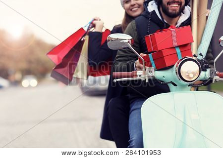 Portrait of happy couple with shopping bags after shopping in city