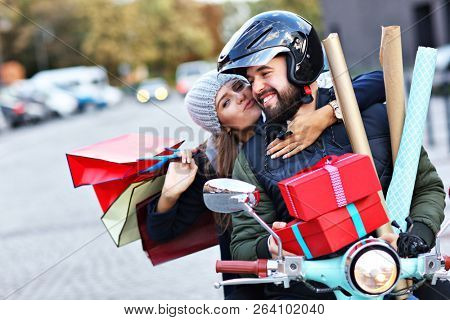 Portrait of happy couple with shopping bags after shopping in city