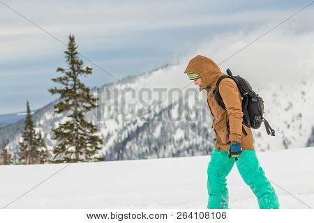 Snowboarder Girl Freerider Is Standing In The Snowy Mountains In Winter Under The Clouds