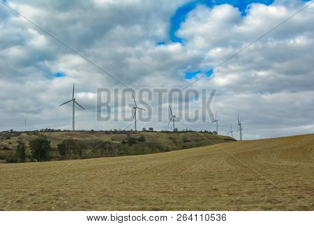Plowed Field And Hill With Windmills In The Fall