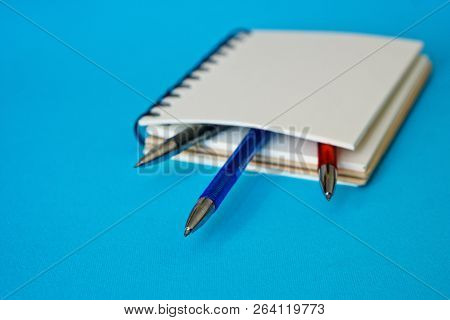 Memory Entries. A Notebook With Colored Pens Lies On A Blue Surface
