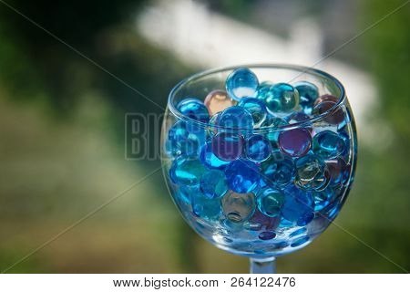 Transparent Glass With Gel Balls On A Dark Green Background. An Unusual Drink.