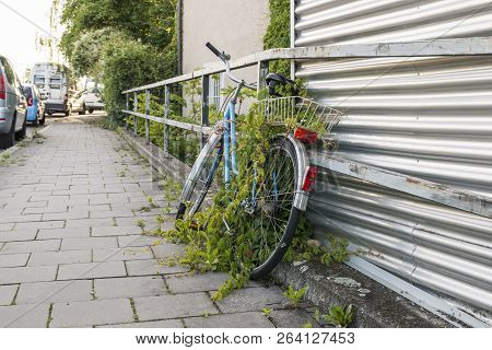Regensburg, Bavaria, Germany - June 17, 2016: One Parked And Overgrown Bicycle On The Roadside At A 