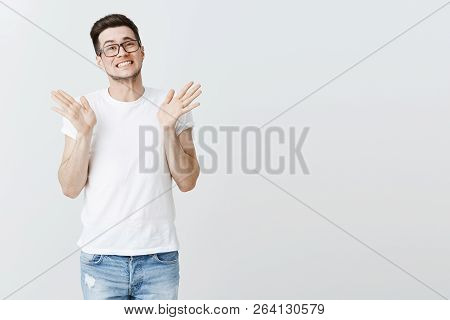 Apologizing Handsome Young Male Coworker In Glasses Raising Hands Near Shoulders And Shrugging With 