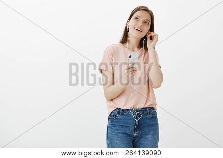 Dreammy Girl Gathers Inspiration From Music, Putting On Earphones, Holding Smartphone And Gathing Up