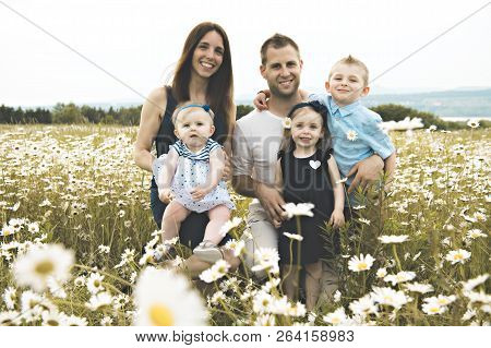 Family Spending Time With Little Child During The Sunset.