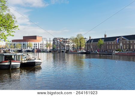 Embankments Of Amstel Canal With Traditional Boats And Houses In Amsterdam, Holand