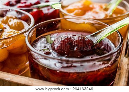 Strawberry Jam In Glass Bowl With Spoon And Various Marmalades Breakfats Concept