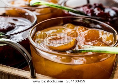 Apricot Jam In Glass Bowl With Spoon And Various Fruit Marmalades