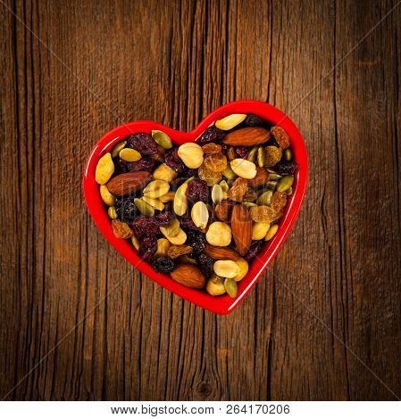 Energy Blend Trail Mix With Nuts And Dried Fruits In Heart Shaped Bowl. Selective Focus.