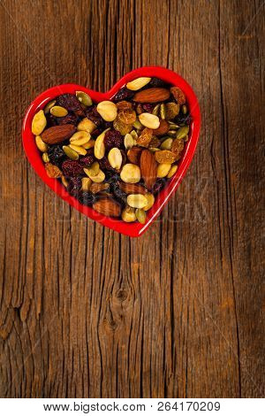 Energy Blend Trail Mix With Nuts And Dried Fruits In Heart Shaped Bowl. Selective Focus.
