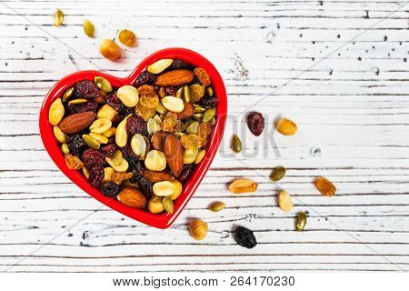 Energy Blend Trail Mix With Nuts And Dried Fruits In Heart Shaped Bowl. Selective Focus.