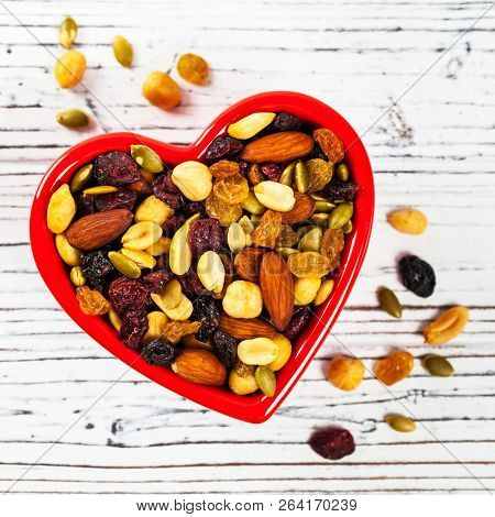 Energy Blend Trail Mix With Nuts And Dried Fruits In Heart Shaped Bowl. Selective Focus.