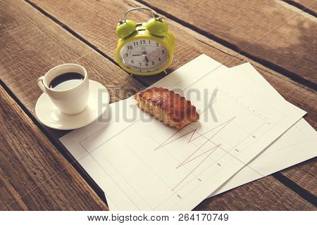 Cup Of Coffee And Clock On Document Paper