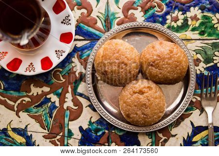 Turkish Dessert Kemalpasa With Tea On A Ottoman Pattern Surface.