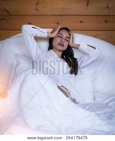 The Beautifu Laday Is Sitting On Bed,closed Her Eyes And Put Hand Touch Her Head,unhappy Feeling,hea