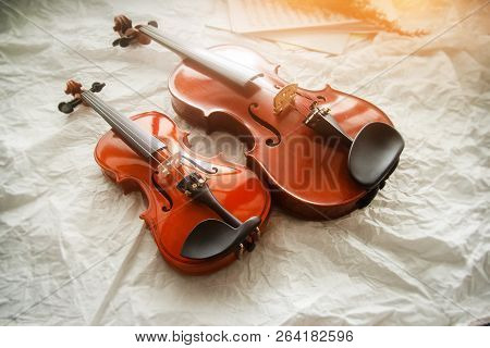 Two Different Size Of Violins Put On Background,warm Light Tone,blurry Light Adesign Background