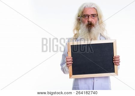 Studio Shot Of Senior Bearded Man Doctor Holding Blank Blackboar