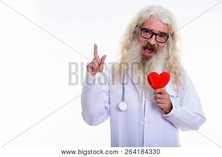 Studio Shot Of Happy Senior Bearded Man Doctor Smiling And Holdi