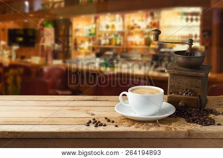 Coffee Cup With Grinder Mill On Wooden Table Over Restaurant Interior Background With Copy Space