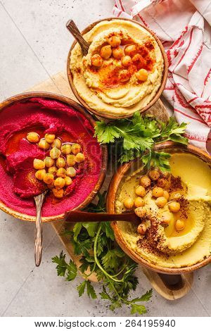 Different Hummus Bowls. Chickpea Hummus, Avocado Hummus And Beet Hummus. Plant Based Diet Food.