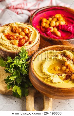 Different Hummus Bowls. Chickpea Hummus, Avocado Hummus And Beet Hummus. Plant Based Diet Food.