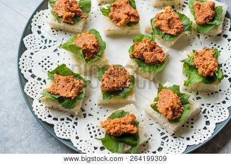 Canape With Muhammara, Adjika, Ajika Or Acuka On Small Square Breads With Round Plate.