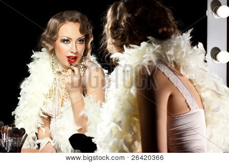 fashionable woman with make-up brush near the mirror