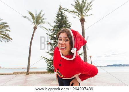 Christmas, Holidays And Humor Concept - Young Happy Woman Have Fun In Christmas Suit At Summer Near 