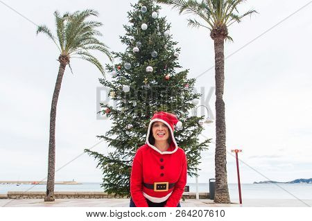 Christmas, Holidays And Humor Concept - Young Happy Woman Have Fun In Christmas Costume At Summer Ne