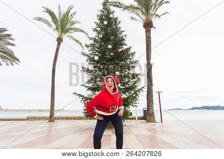 Christmas, Holidays And Humor Concept - Young Happy Woman Have Fun In Christmas Costume At Summer Ne