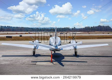 A Large White Prop Driven Plane On Tarmac From Rear