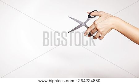 Female Hand Is Holding Scissors. Copy Space For Your Text. Isolated On White Background.