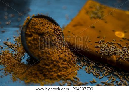 Close Up Of Powdered Cumin Or Zeera Or Jeera With Raw Cumin On Wooden Surface In A Clay Bowl On A Cl