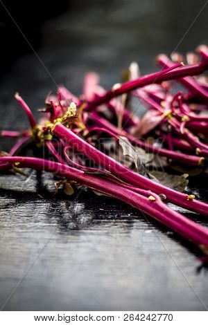 Close Up Of Raw Amaranth Leaves's Branches On Wooden Surface Without Its Leaves.