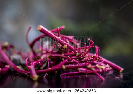 Close Up Of Raw Amaranth Leaves's Branches On Wooden Surface Without Its Leaves.