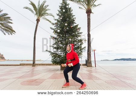 Christmas, Holidays And Humor Concept - Young Happy Woman Have Fun In Christmas Costume At Summer Ne