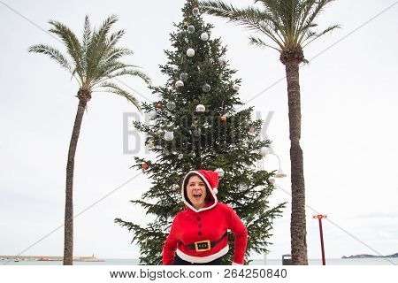 Christmas, Holidays And Humor Concept - Young Happy Woman Have Fun In Christmas Costume At Summer Ne