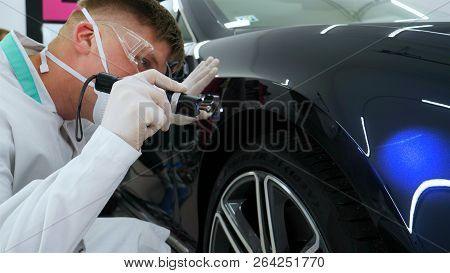 Professional Master After Polishing And Painting Cars, Checks The Flashlight Scratches, A Respirator