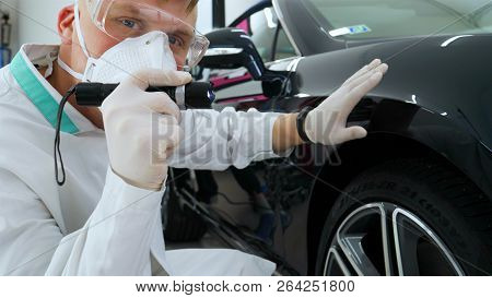 Professional Master After Polishing And Painting Cars, Checks The Flashlight Scratches, A Respirator