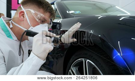 Professional Master After Polishing And Painting Cars, Checks The Flashlight Scratches, A Respirator
